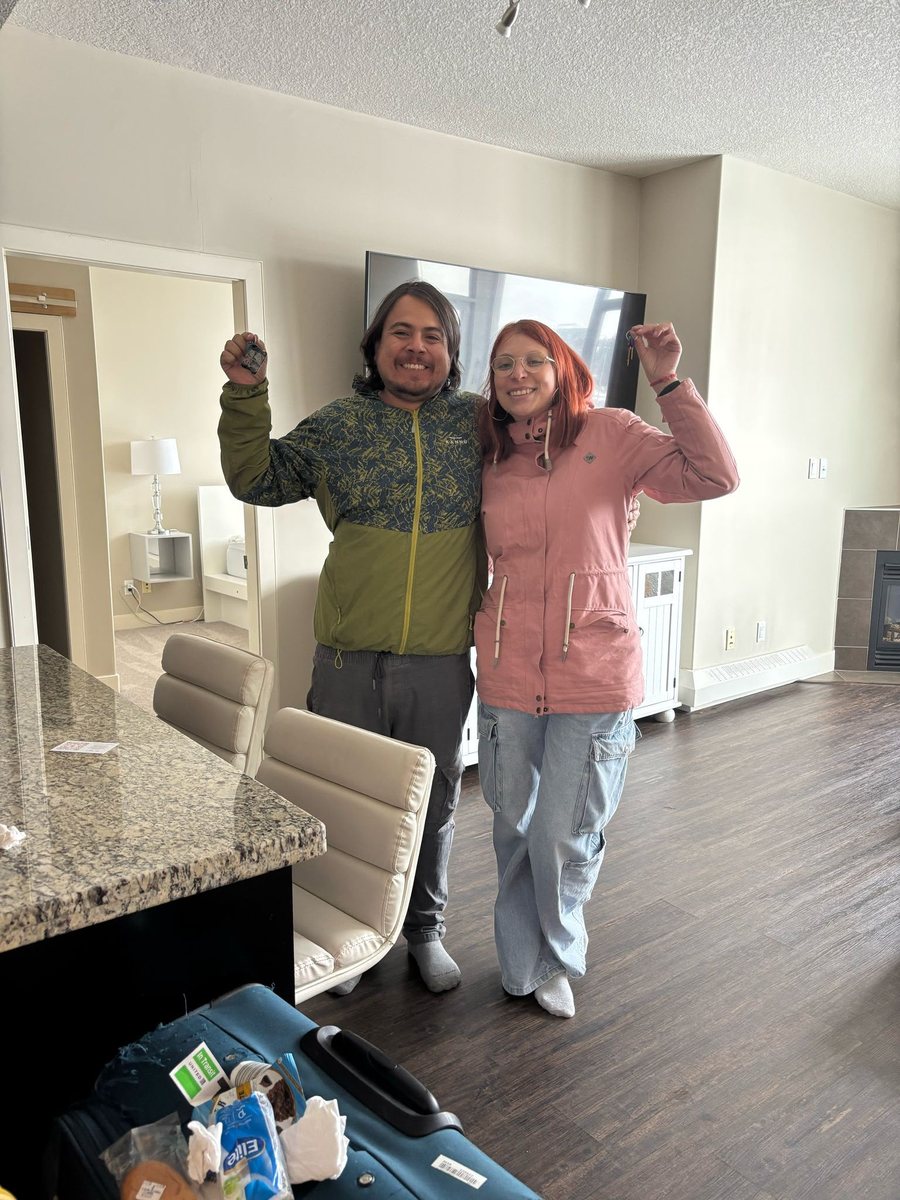 Pareja celebrando con llaves en su nuevo hogar